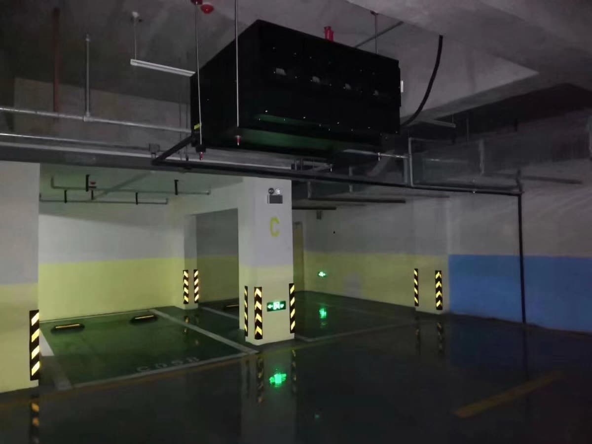 吊頂式抽濕機安裝於停車場天花，地面可見凝水反光